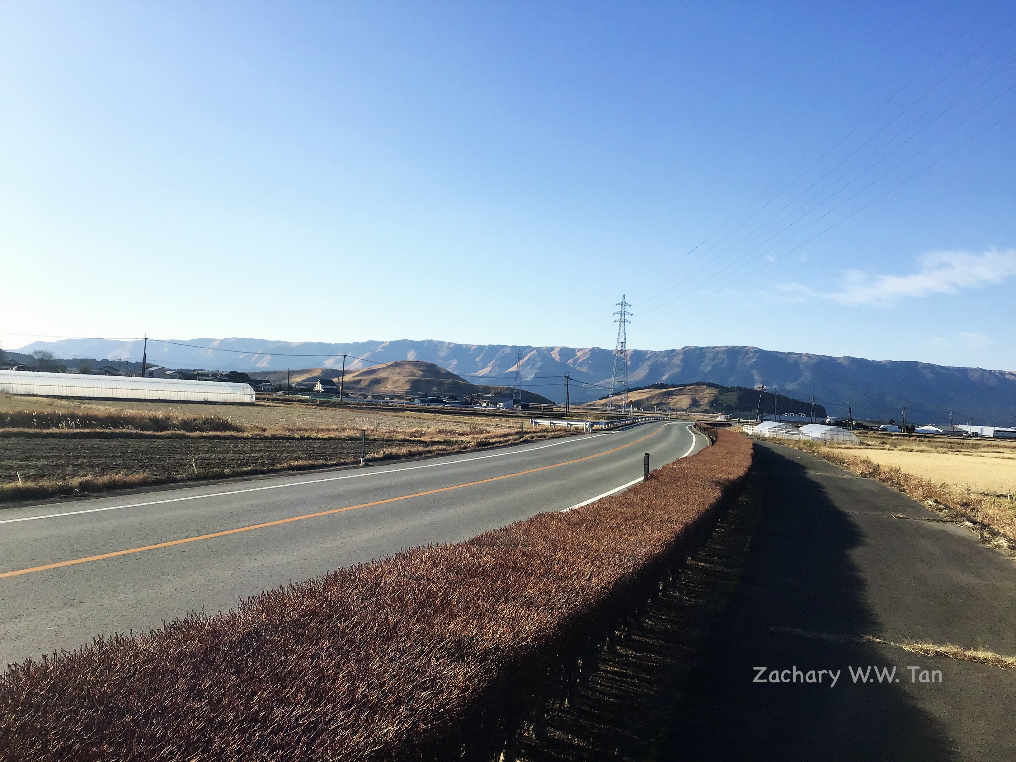 Long countryside road with a mountain range in the background