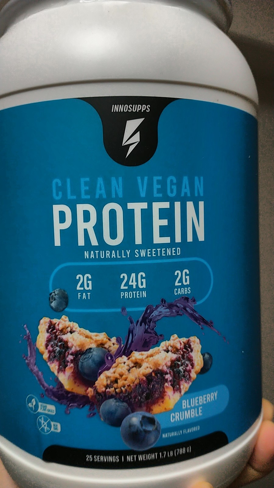 A container of protein powder with a picture of a blueberry pastry on it